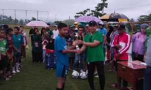 Pelatih nasional Jafri Sastra menyerahkan hadiah juara I kepada pemain SSB Bina Muda